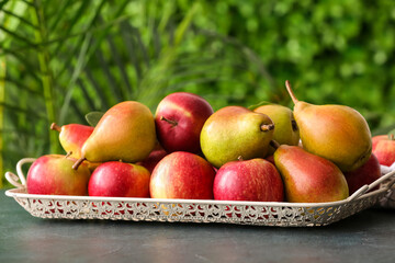 Tray with ripe pears and apples on table outdoors