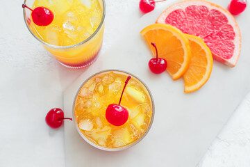 Glasses of tasty Tequila Sunrise cocktail on light background