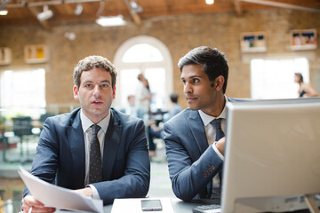 Businessmen working at computer in conference room