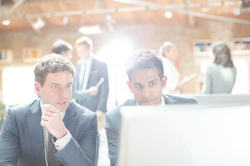 Businessmen working at computer in conference room