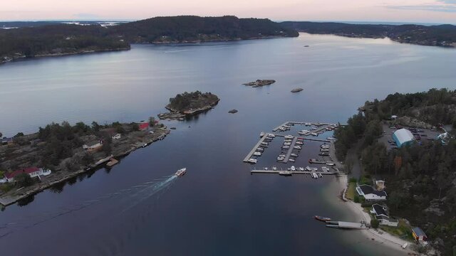 Idyllic location with beach, dock and summer cabins in Kragerofjorden; golden hour