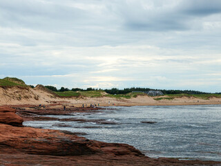 View of Prince Edward Island National Park on a cloudy day with people in distance.