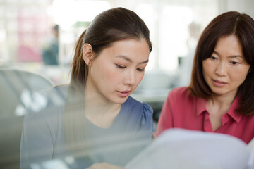 Businesswomen discussing paperwork in office