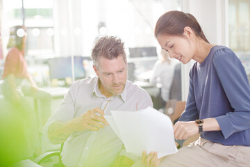 Business people reviewing paperwork at desk in office