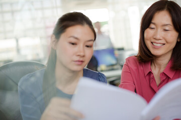 Smiling businesswomen discussing paperwork in office