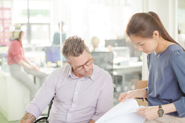 Obraz premium Business people reviewing paperwork at desk in office