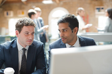 Businessmen working at computer in conference room