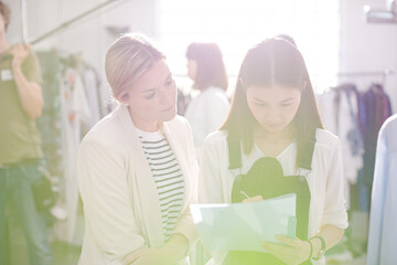 Obraz premium Fashion designer watching assistant taking notes