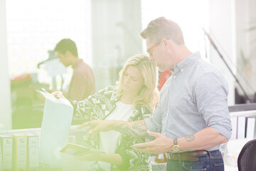 Fototapeta premium Fashion designers discussing fabric swatch in sunny office