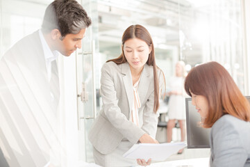 Obraz premium Business people reviewing paperwork at desk in office