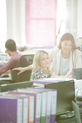 Fashion designers talking at desk in office