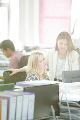 Fashion designers talking at desk in office