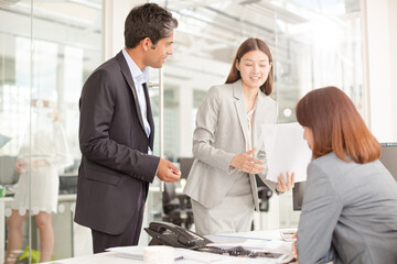 Business people reviewing paperwork at desk in office