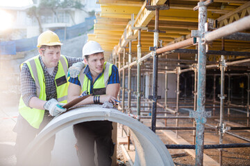 Portrait confident engineers with clipboard at construction site