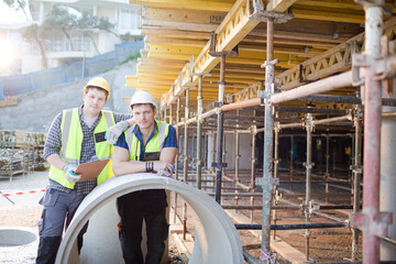 Portrait confident engineers with clipboard at construction site