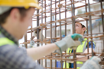 Constructor workers assembling rebar structure at construction site