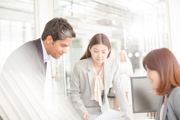 Business people reviewing paperwork at desk in office