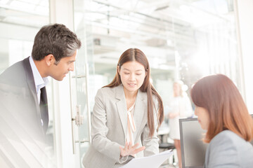 Fototapeta premium Business people reviewing paperwork at desk in office