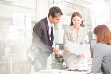 Business people reviewing paperwork at desk in office