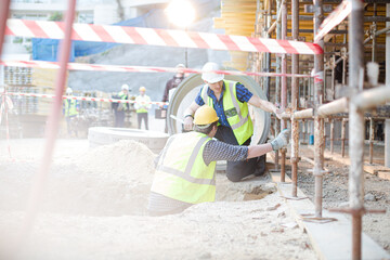 Construction workers using level tool at construction site