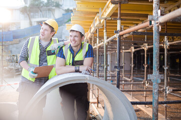 Portrait confident engineers with clipboard at construction site