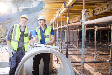 Portrait confident engineers with clipboard at construction site