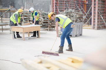 Construction worker sweeping at construction site