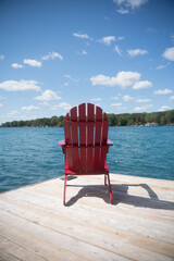 Red Muskoka Chair with a Waterfront View at a Cottagee