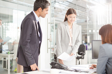 Business people reviewing paperwork at desk in office