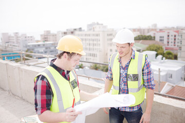 Construction worker engineer reviewing blueprints at highrise construction site