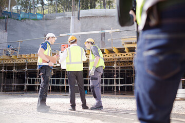 Construction worker engineer reviewing blueprints at construction site