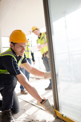 Construction worker measuring window at construction site