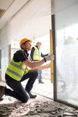 Construction worker measuring window at construction site