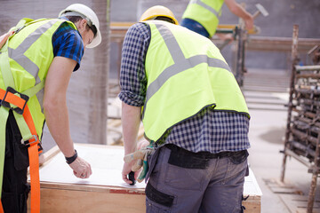 Construction worker engineer reviewing blueprints at construction site