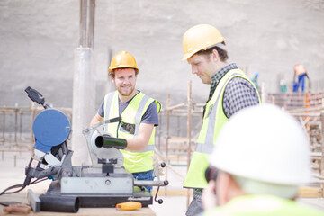 Construction workers adjusting metal bar at construction site