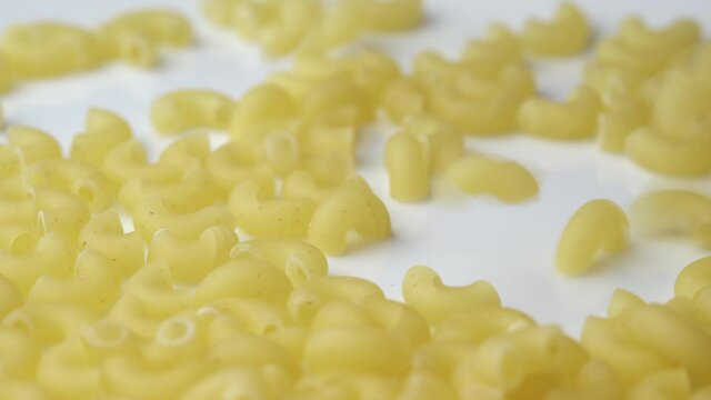 The macaroni cones are sprinkled on the plate in close-up and spinning. Background of spinning Italian pasta