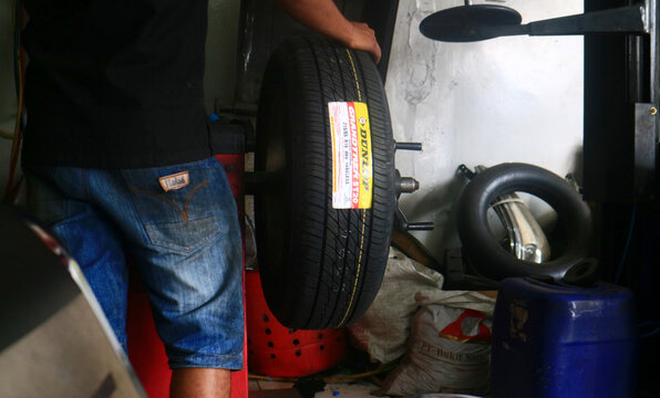 Depok, Indonesia - September 3, 2021: The technician does tire balancing before it is installed on the car.