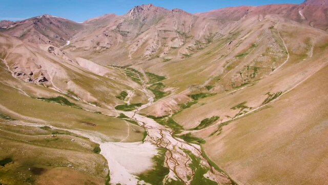 Arid Valley Landscape With Moss On Dry River In Namangan Region Near Arashan Mountain Lakes In Uzbekistan. aerial pullback