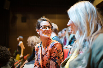 Businesswomen talking in conference audience