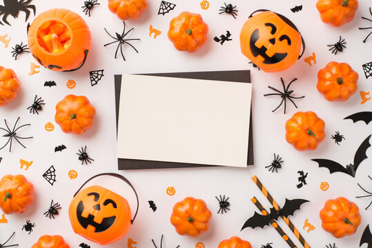 Top view photo of black envelope white card pumpkin baskets candy corn straws spiders cats witches and bats silhouettes on isolated white background with empty space