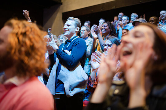 Smiling, enthusiastic woman cheering in audience