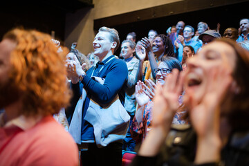Smiling, enthusiastic woman cheering in audience
