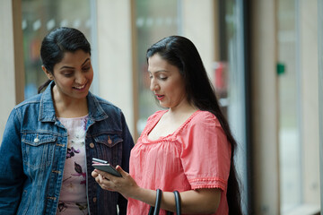 Two woman talking in hall of auditorium