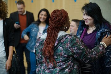 Two women greeting in hallway