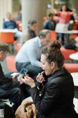 Woman applying make up in hall of auditorium