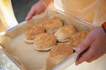 Fresh homemade burger buns on a tray.
