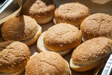 Fresh homemade burger buns on a tray.