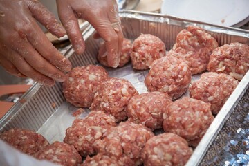 A person prepares cutlets from fresh minced meat. Balls of fresh minced meat.