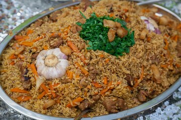 Fresh pilaf with garlic is cooked in a cauldron.