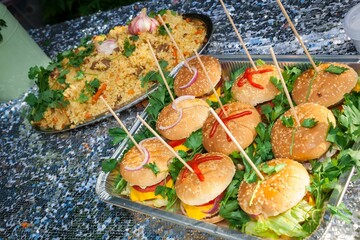 Fresh burgers and pilaf are served on the table.